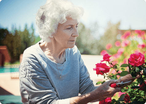 Lifestyle photography supporting impact data Older woman with white hair sitting outdoors near flowers, representing daily activities affected by GA progression